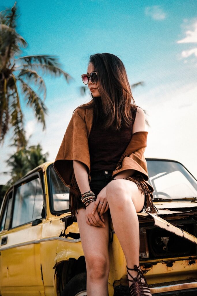 a woman sitting on the hood of a car
